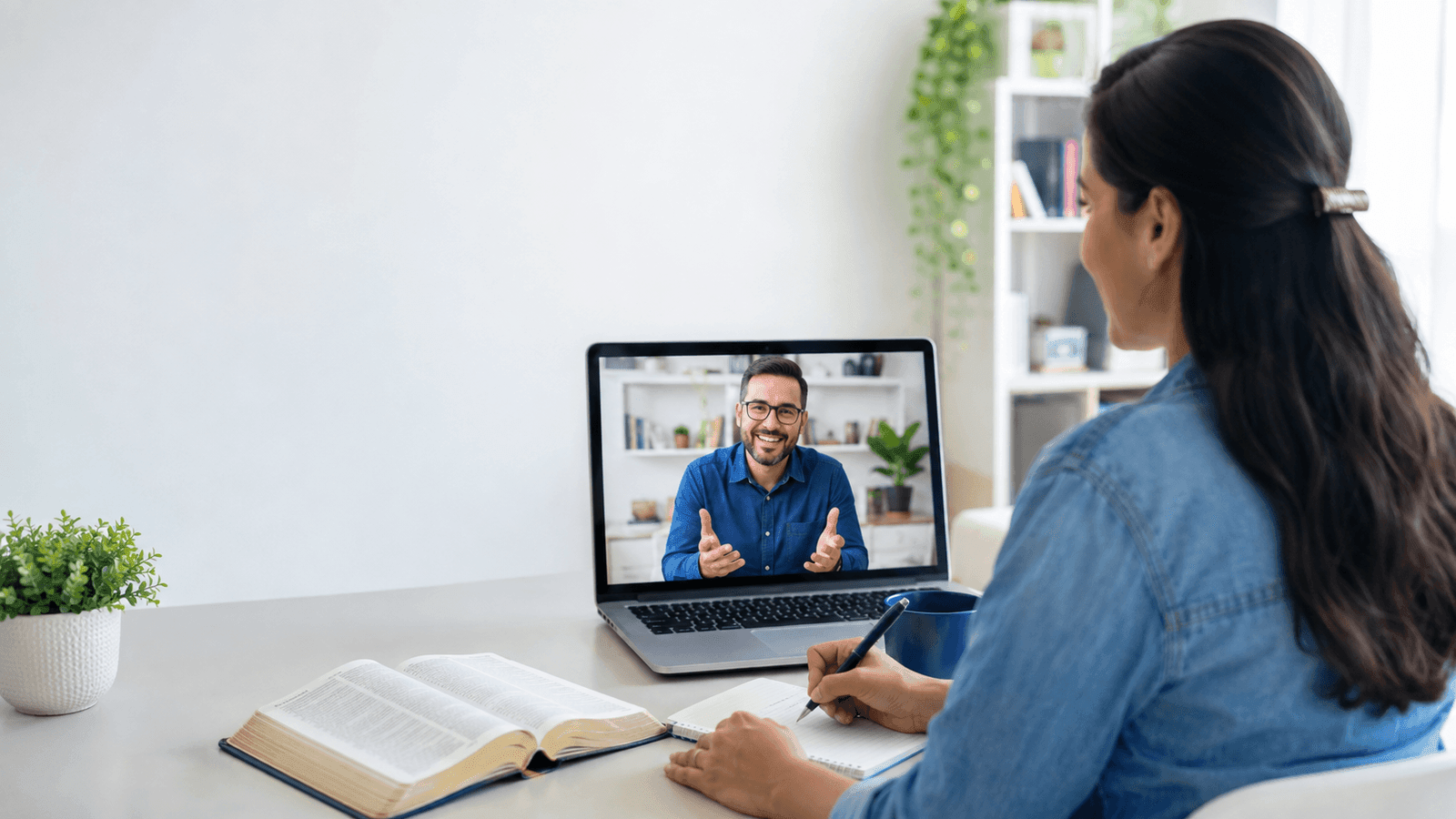 Aluna estudando a Bíblia em uma aula on-line com professor